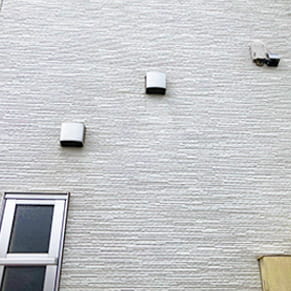 黒ずんで堆積していた排気口近くの汚れが綺麗に取れた外壁の様子