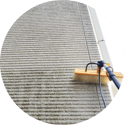 外壁専用の洗浄器具を使い、外壁をこすっている様子