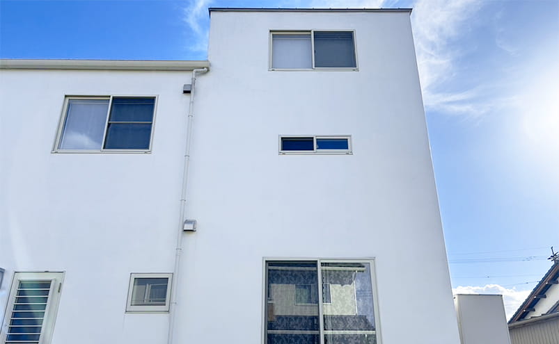 専用の器具を使用し外壁洗浄した後の白い壁の家